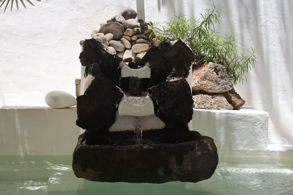 Ein kleiner Brunnen mit schwarzen Steinen. Foto: Niklas Brose